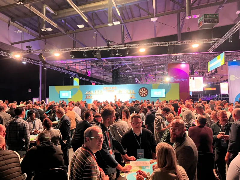 A packed conference hall with a lit stage