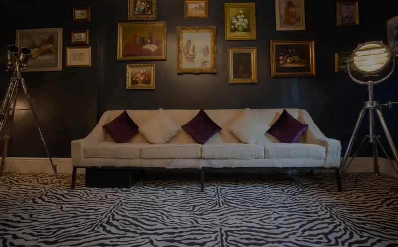 The parlour at CuVée VIII, with gold-framed paintings and a zebra rug
