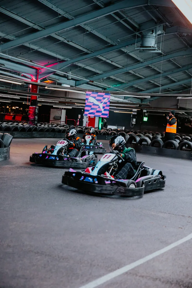 Karts racing on an indoor track at a PUMA event