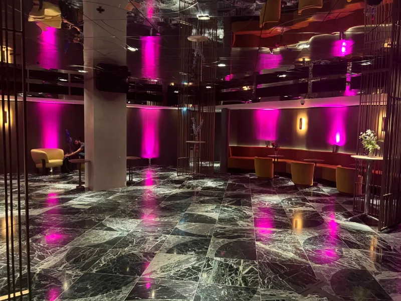 An empty venue lit pink, with a marble floor