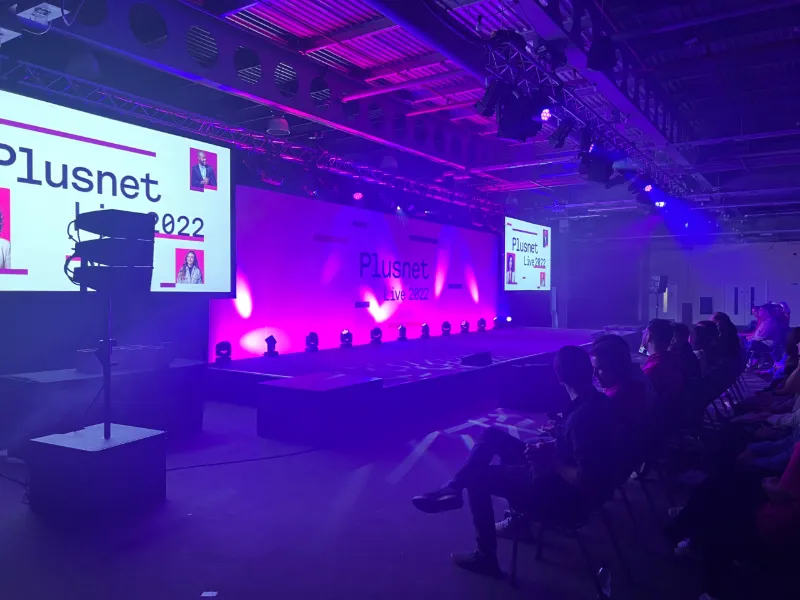 A Plusnet event stage in purple light