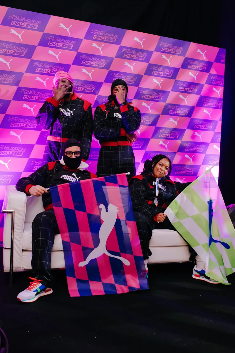 Performers and guests on the purple-and-pink check set at a PUMA launch event