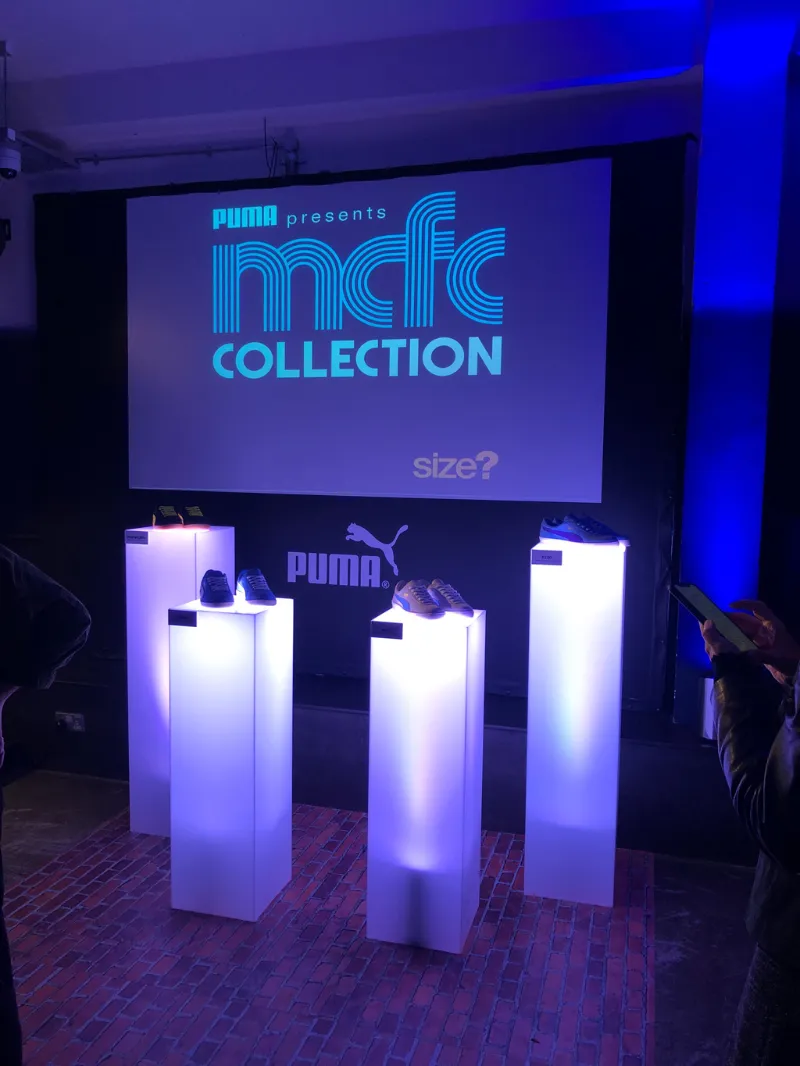 The PUMA MCFC Collection display: white plinths in blue light
